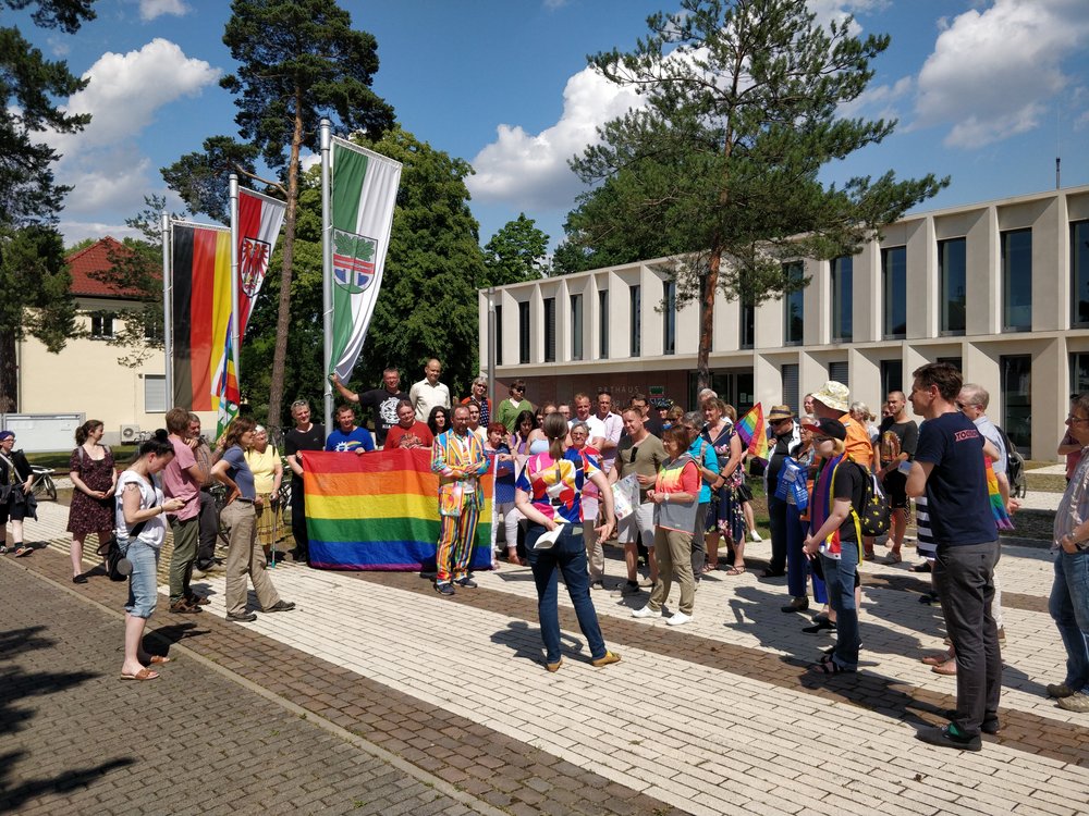 Rund 100 Bürgerinnen und Bürger protestieren vor dem Dallgower Rathaus für Toleranz und Vielfalt, nachdem die Regenbogenflagge angezündet worden war. 